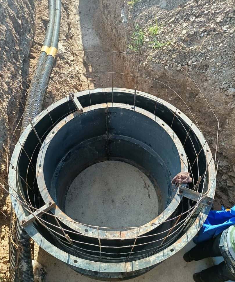 Circular steel formwork for a concrete manhole chamber in an open trench