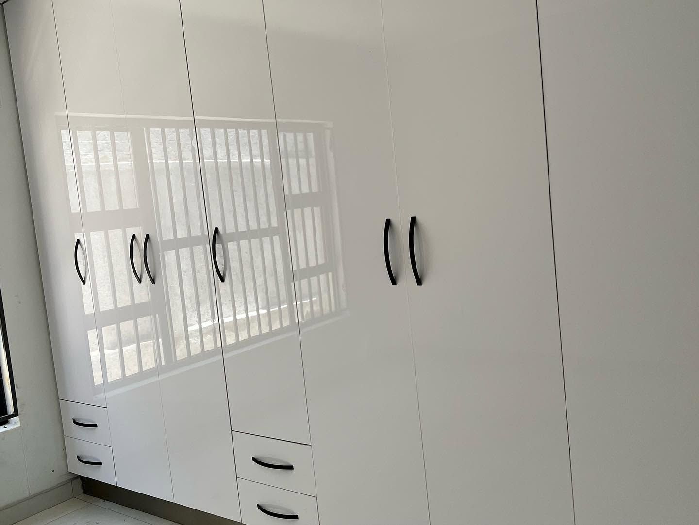 Finished kitchen with dark cabinetry, timber detail, and fitted appliances