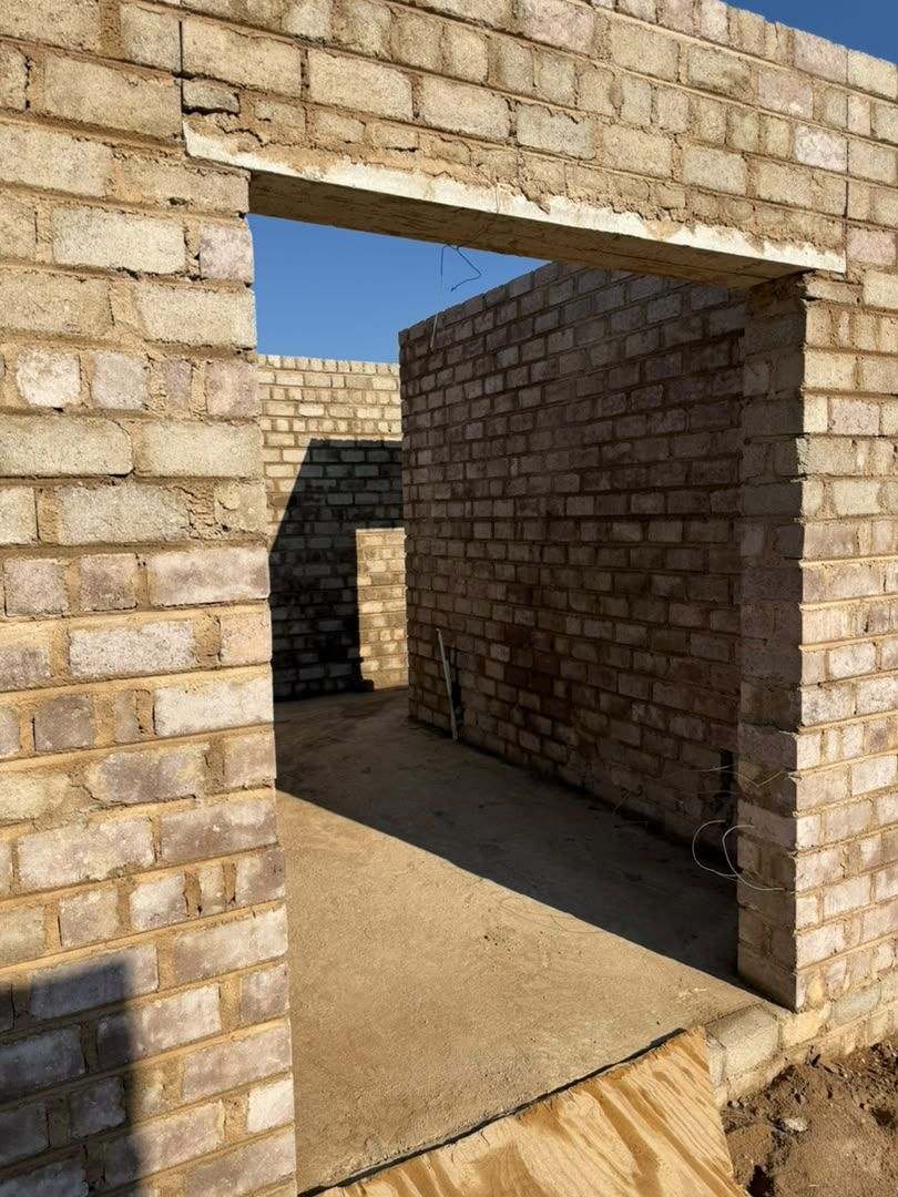 Cast concrete lintel over a squared doorway opening in blockwork