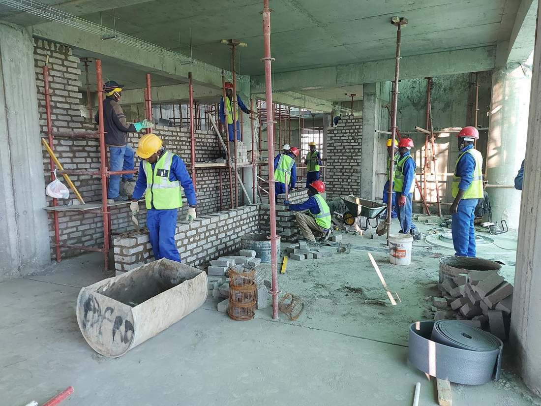 Construction crew working on masonry inside a concrete structure